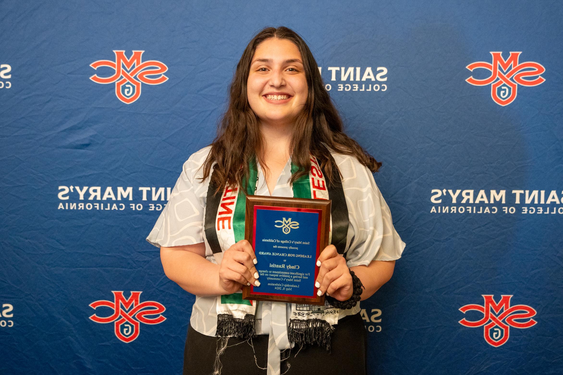 Cindy Rantisi holds up a plaque for 2024 Student Leadership Awards