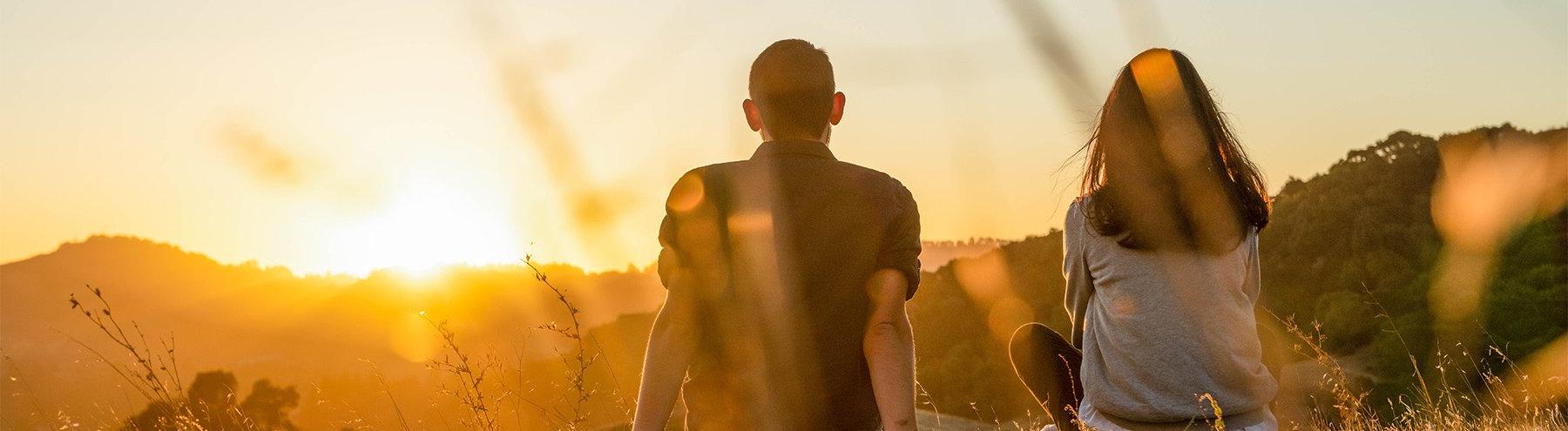 Students sit atop mountain overlooking the sunset